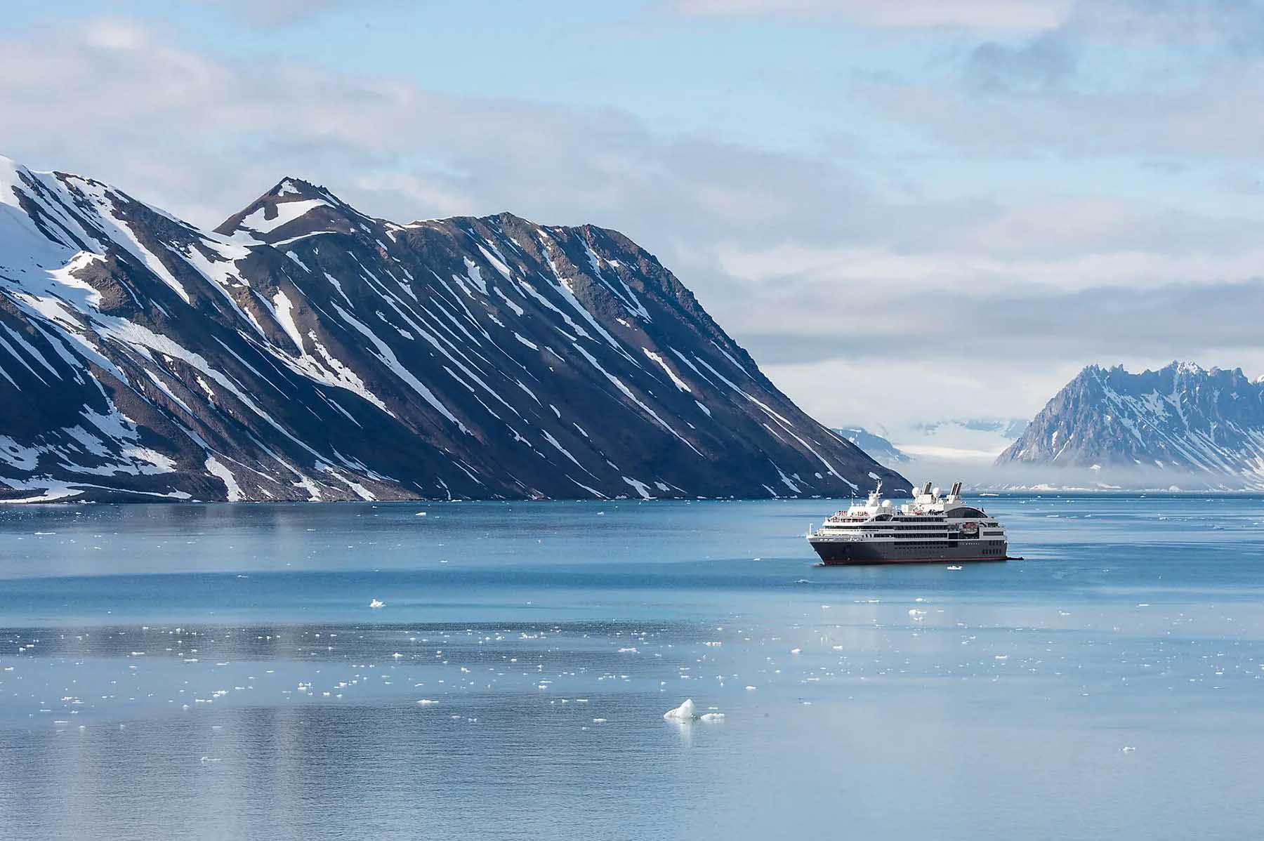 A Ponant cruise ship sails past polar landscapes