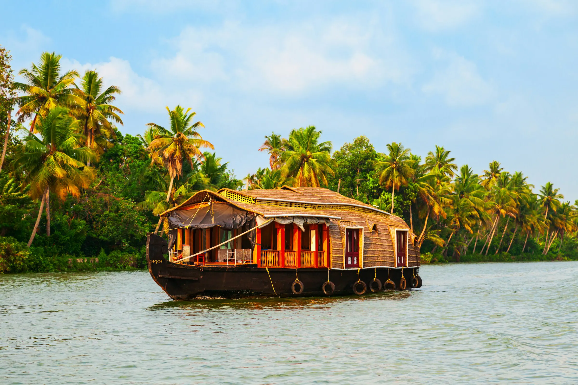 A houseboat travels down a Kerala watera