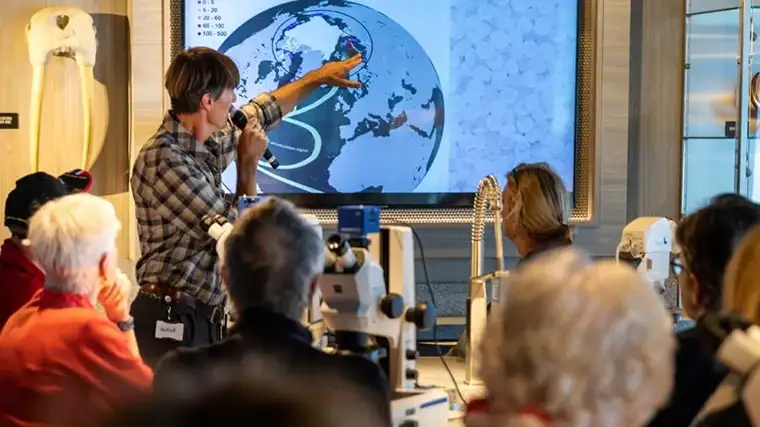 An expert guide gives a presentation onboard an HX Expedition cruise ship