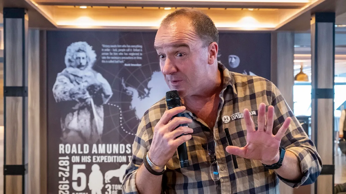 A guide gives a lecture on an HX Expedition cruise ship