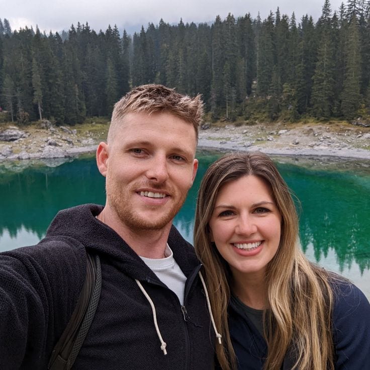 Meg and Pat of Sea2Peak, standing in front of a mountain lake