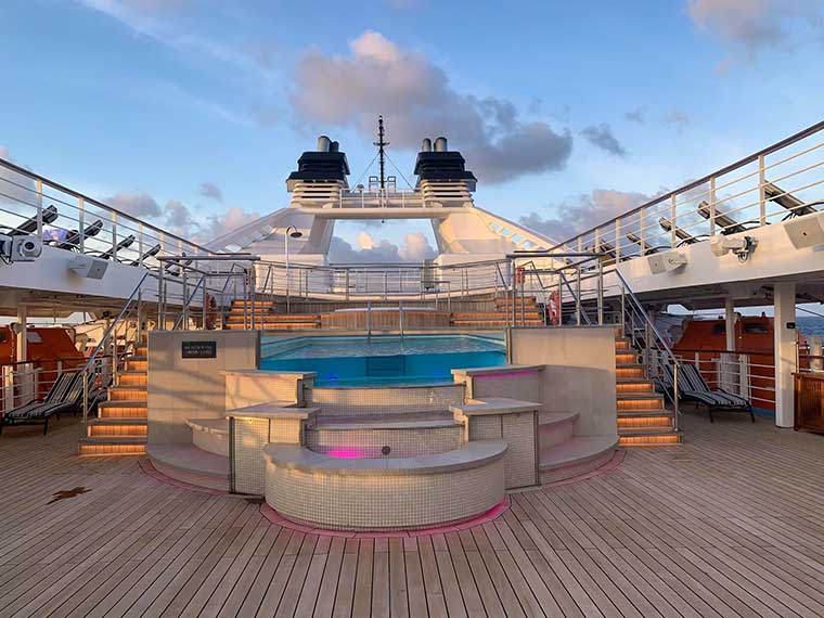 Pool deck on Windstar Star Breeze with sun loungers and ocean views