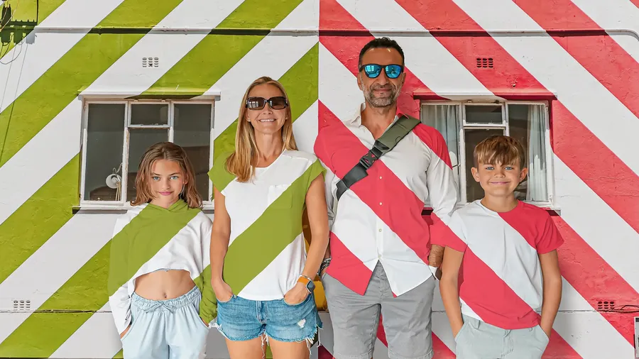 The Lockwood family standing in front of the striped building of Bo Kaap