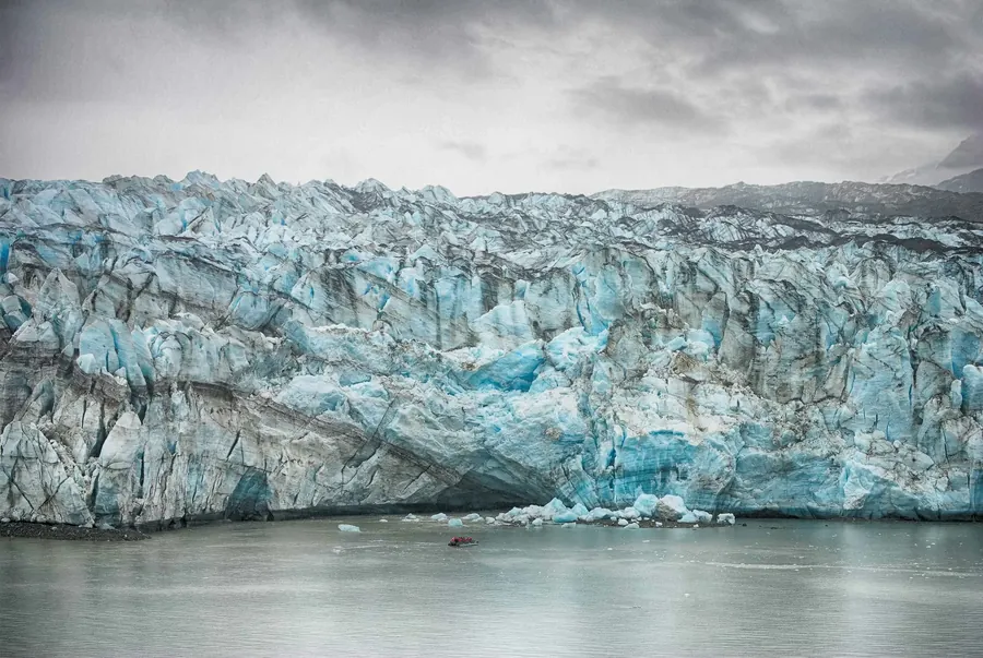 2 zodiacs cruise past a massive glacier in Alaska
