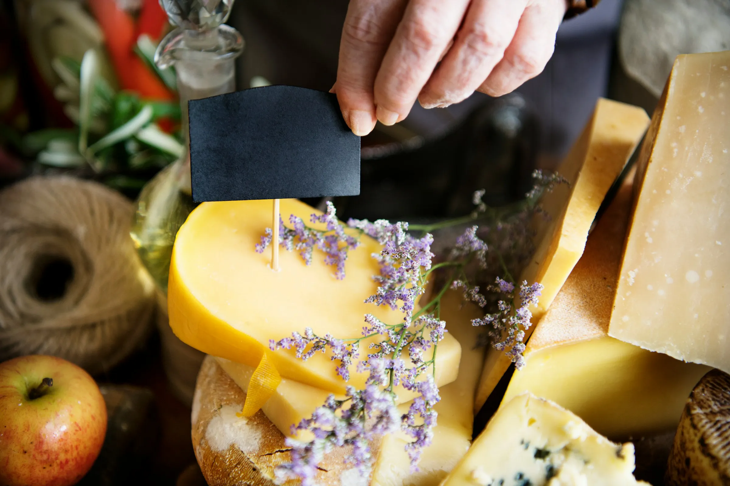 A hand assembles a cheese board