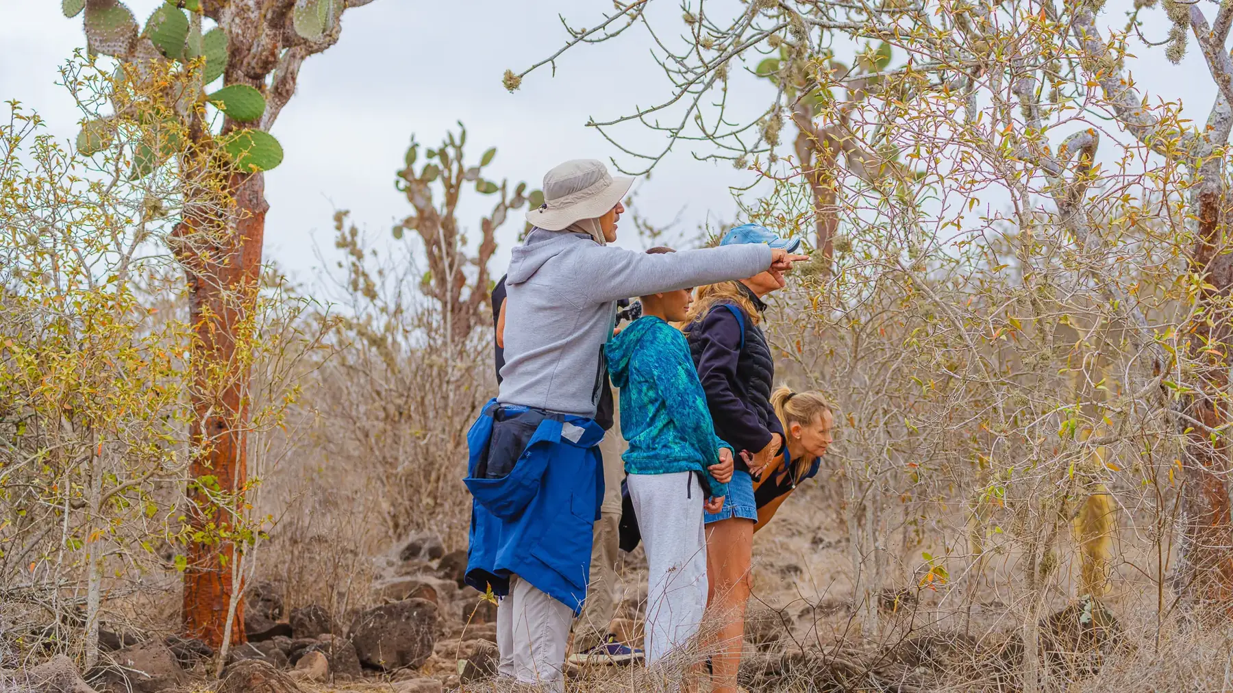 A Galapagos guide points to something for guests to see