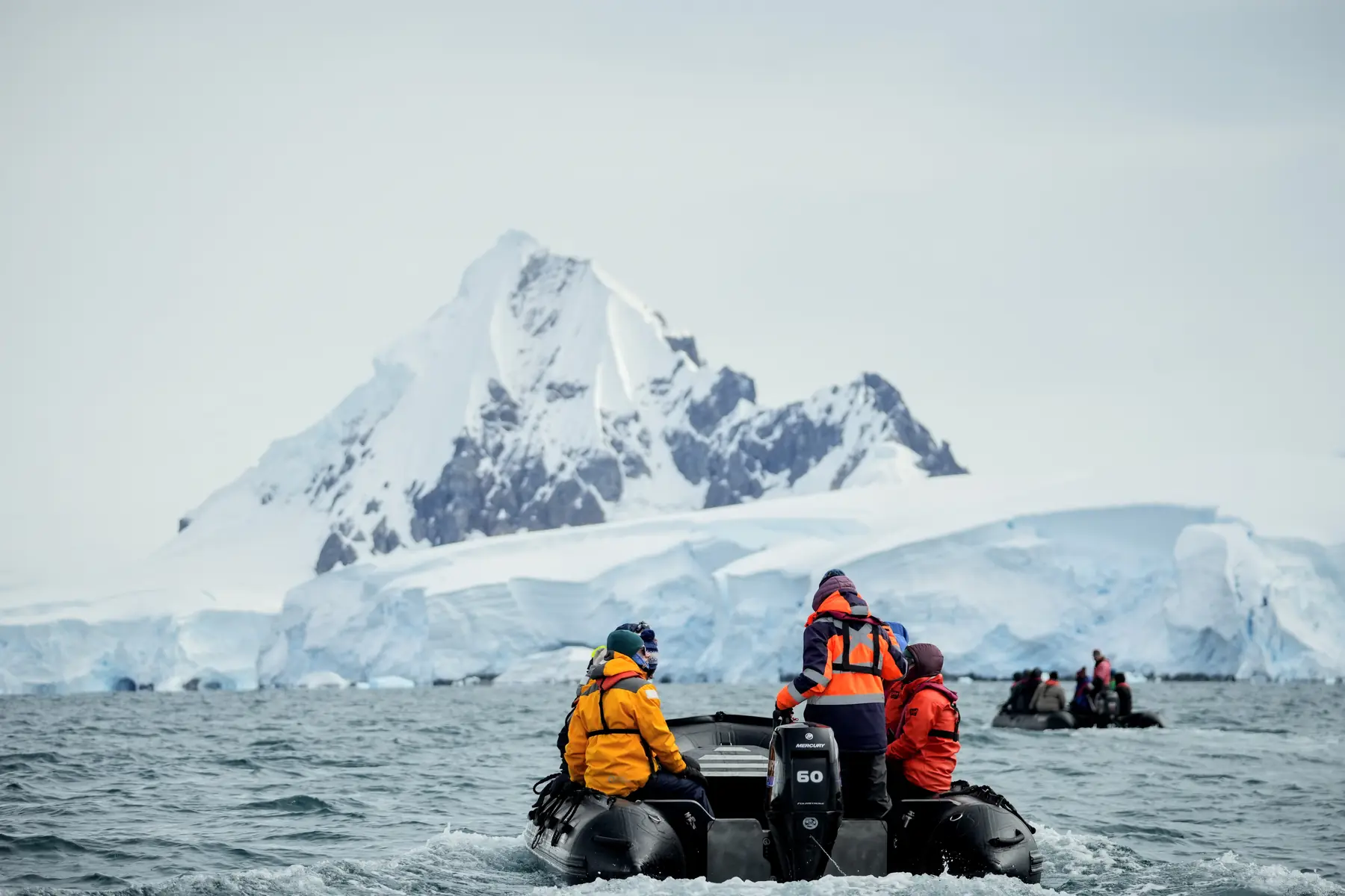 A zodiac with passengers floats in Antarctica