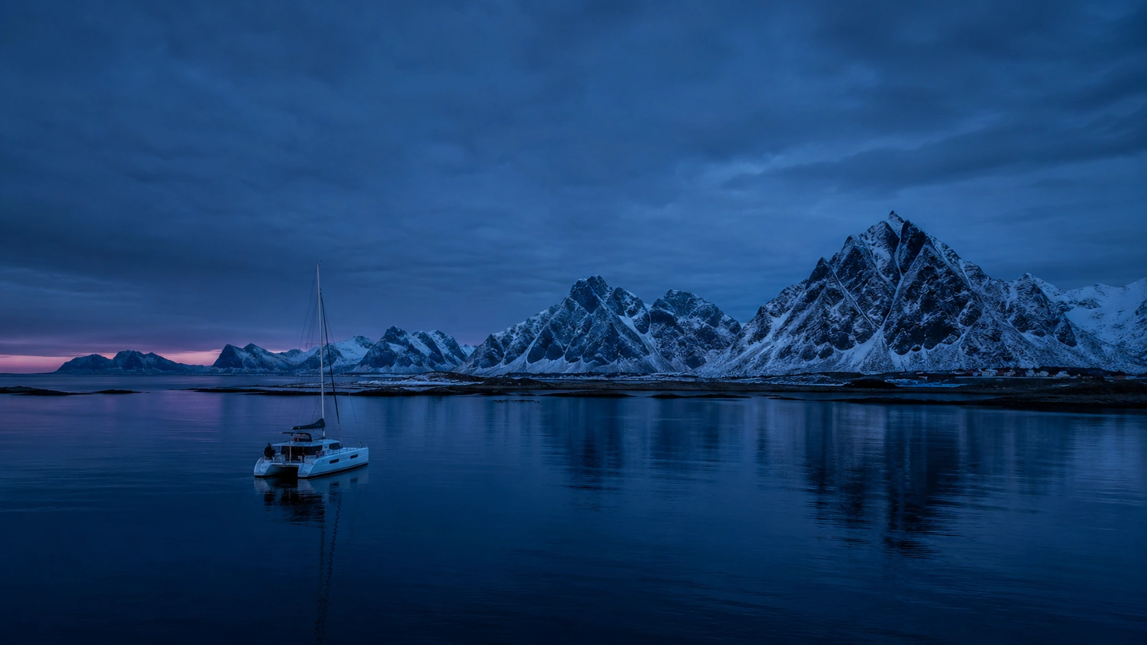 Aerial view of the expedition catamaran cruising Arctic Norway at dusk