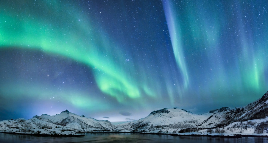 Northern lights glowing green over the night sky in Arctic Norway