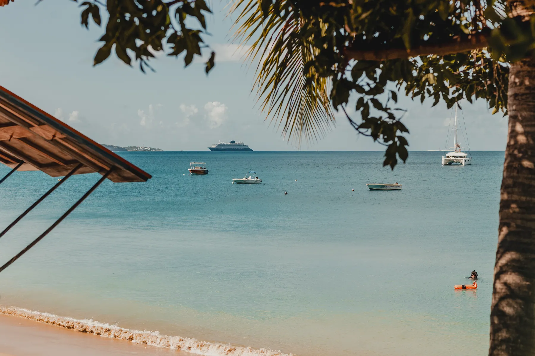 View of Caribbean beach with boats in the distance