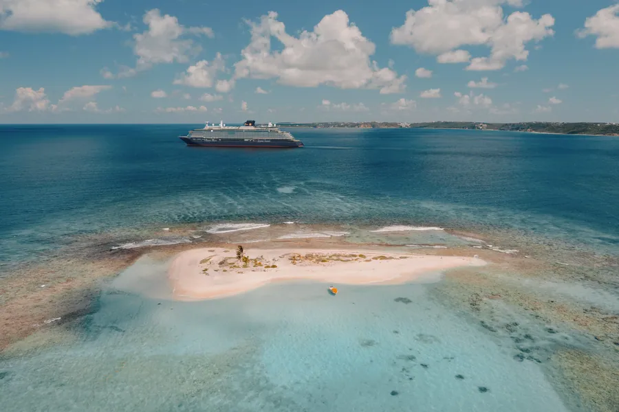 Aerial view of the Explora III cruise ship anchored off a reef island in the Caribbean