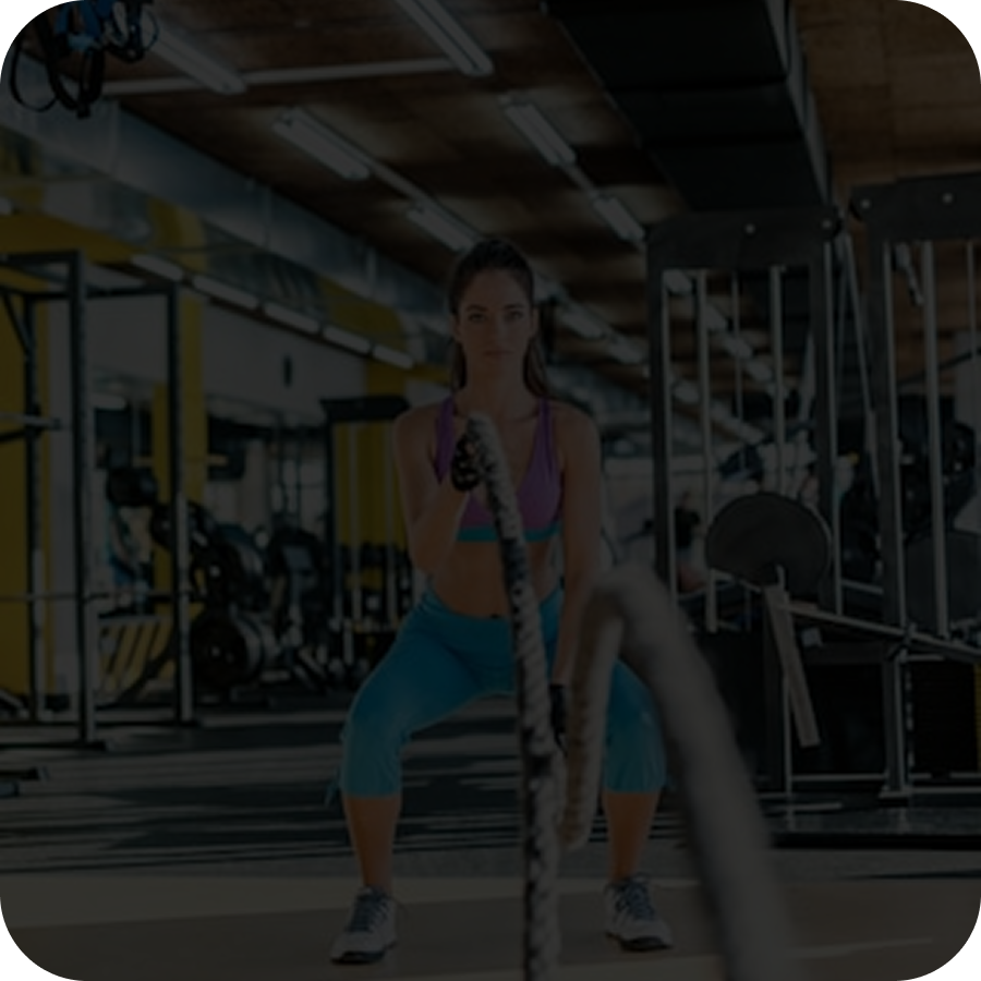 Woman performing battle rope workout in gym