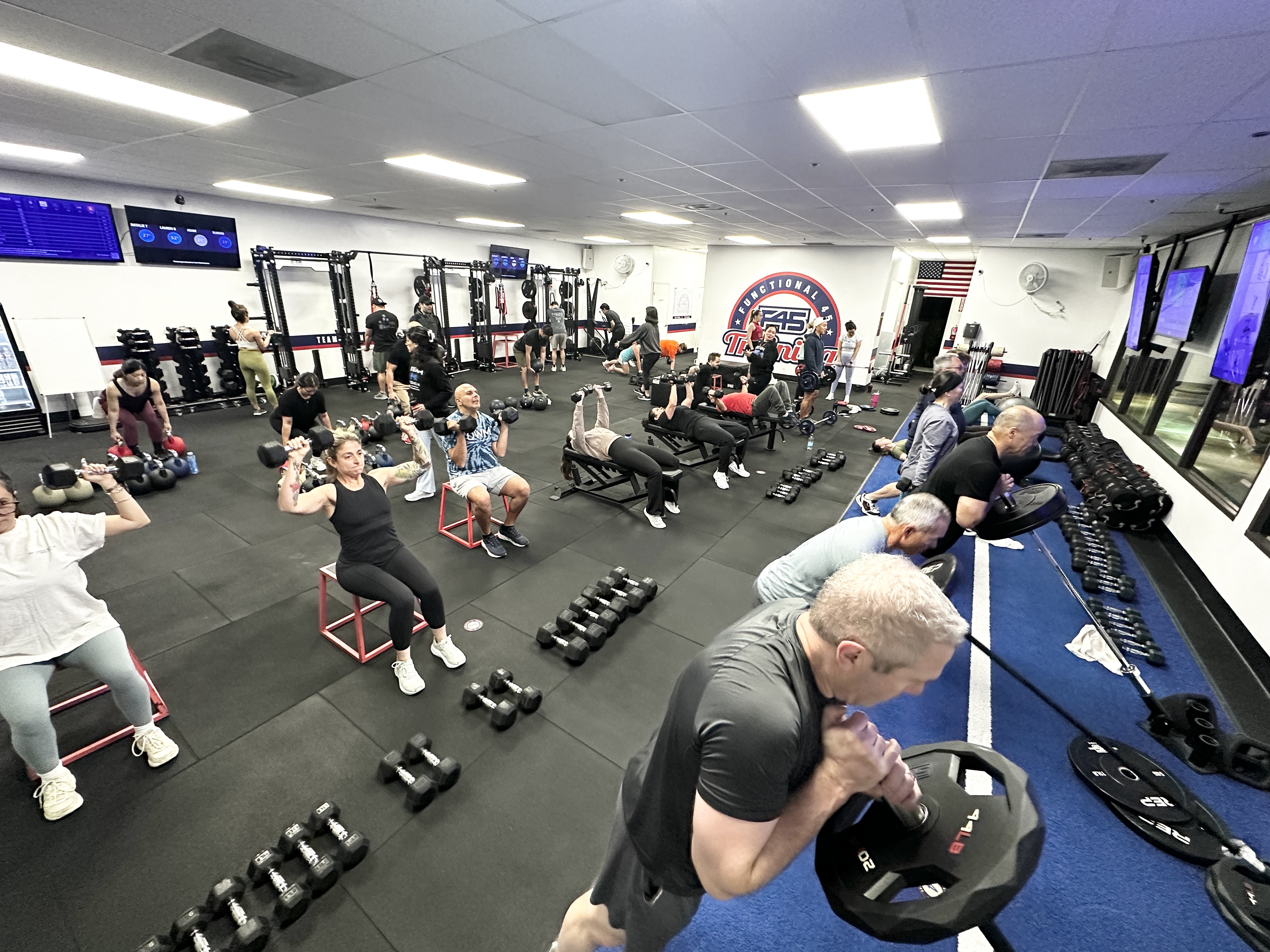 Modern gym floor with free weights and training equipment