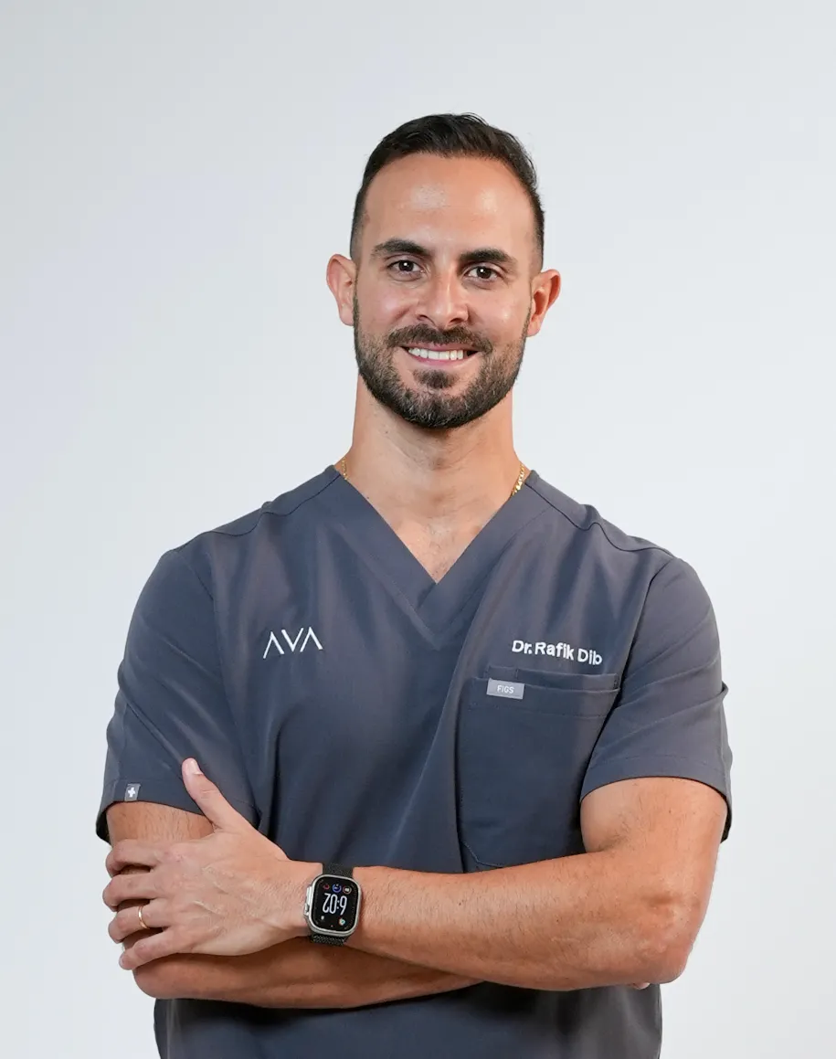 Experienced dentist, Dr. Rafik at Ava Dental standing confidently inside a modern treatment room.