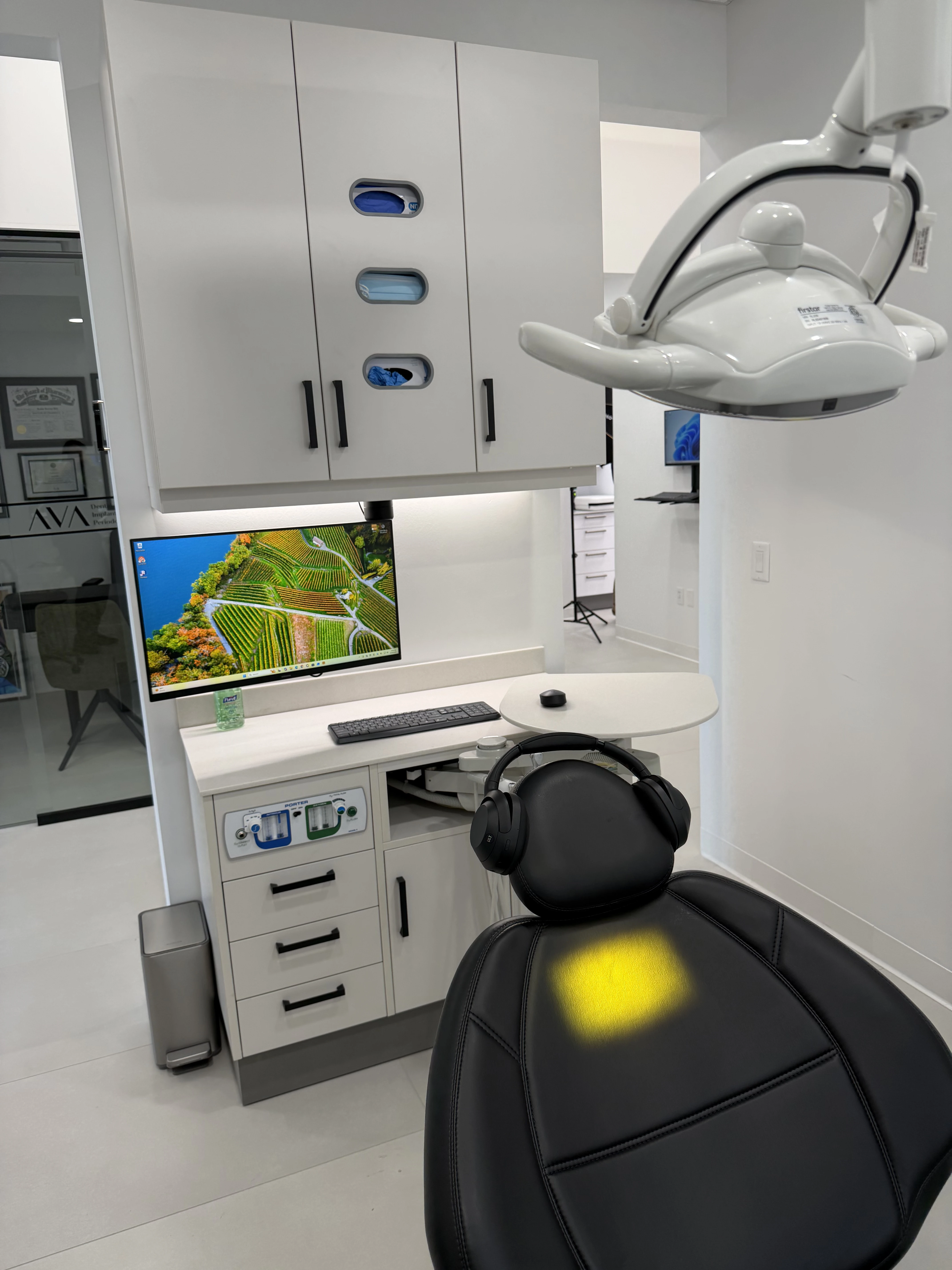 Dentist in white coat reviewing patient information with a woman sitting in a dental chair.