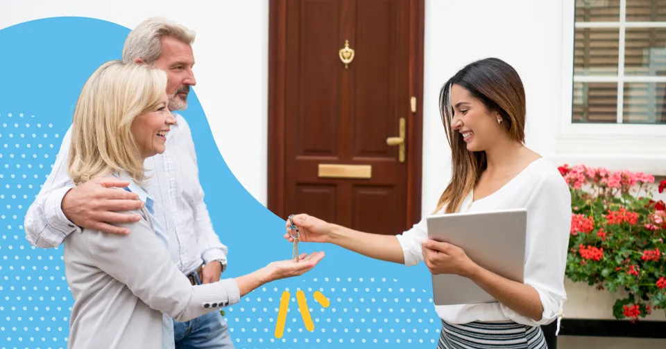Real estate agent handing the keys to two new homeowners