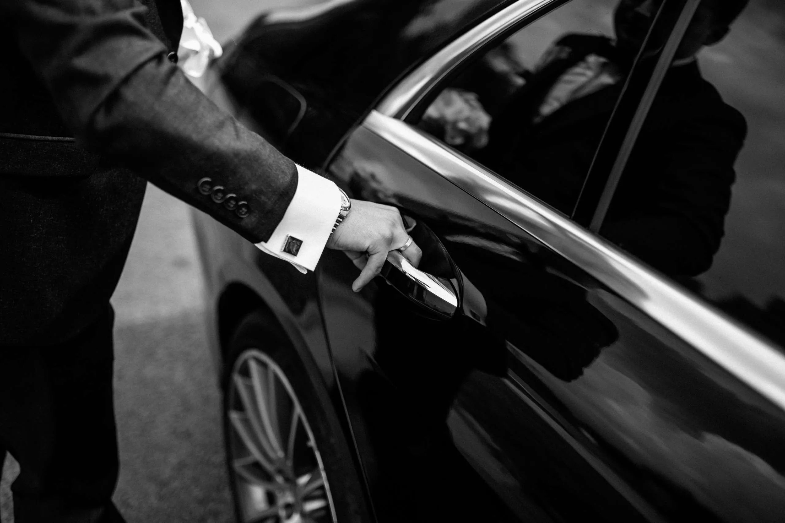 Chauffeur privé professionnel ouvrant portière de berline premium - Service VIP Paris
