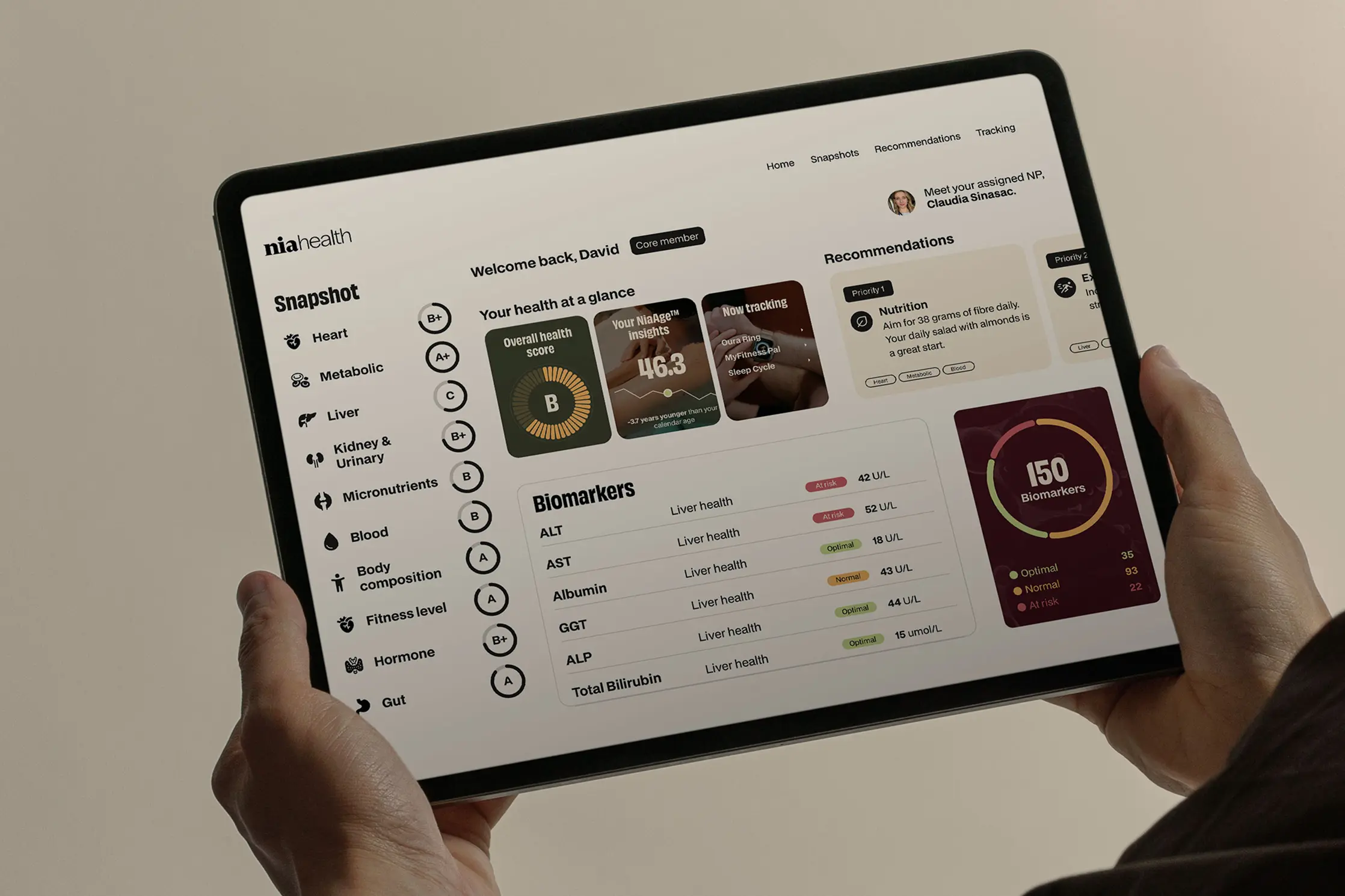 Tablet displaying a health dashboard with biomarker readings, health scores, recommendations, and tracking status.