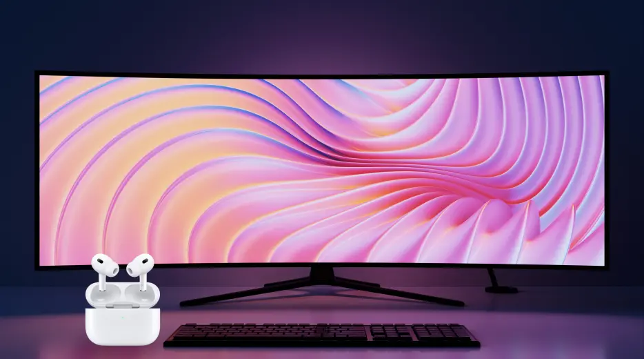 Ultra-wide curved monitor displaying pink and purple abstract waves with wireless earbuds in open charging case and keyboard in front.