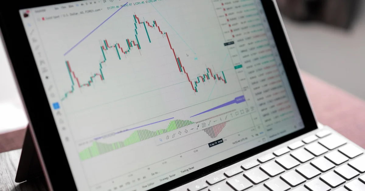 Laptop screen showing detailed forex candlestick chart with technical analysis — how to practice trading stocks