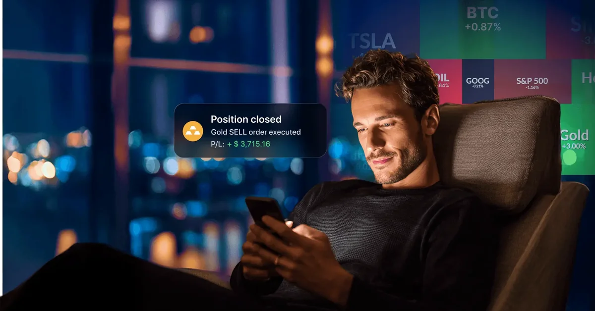 Man relaxing with smartphone showing position closed gold sell notification with stock tickers — best free paper trading platform