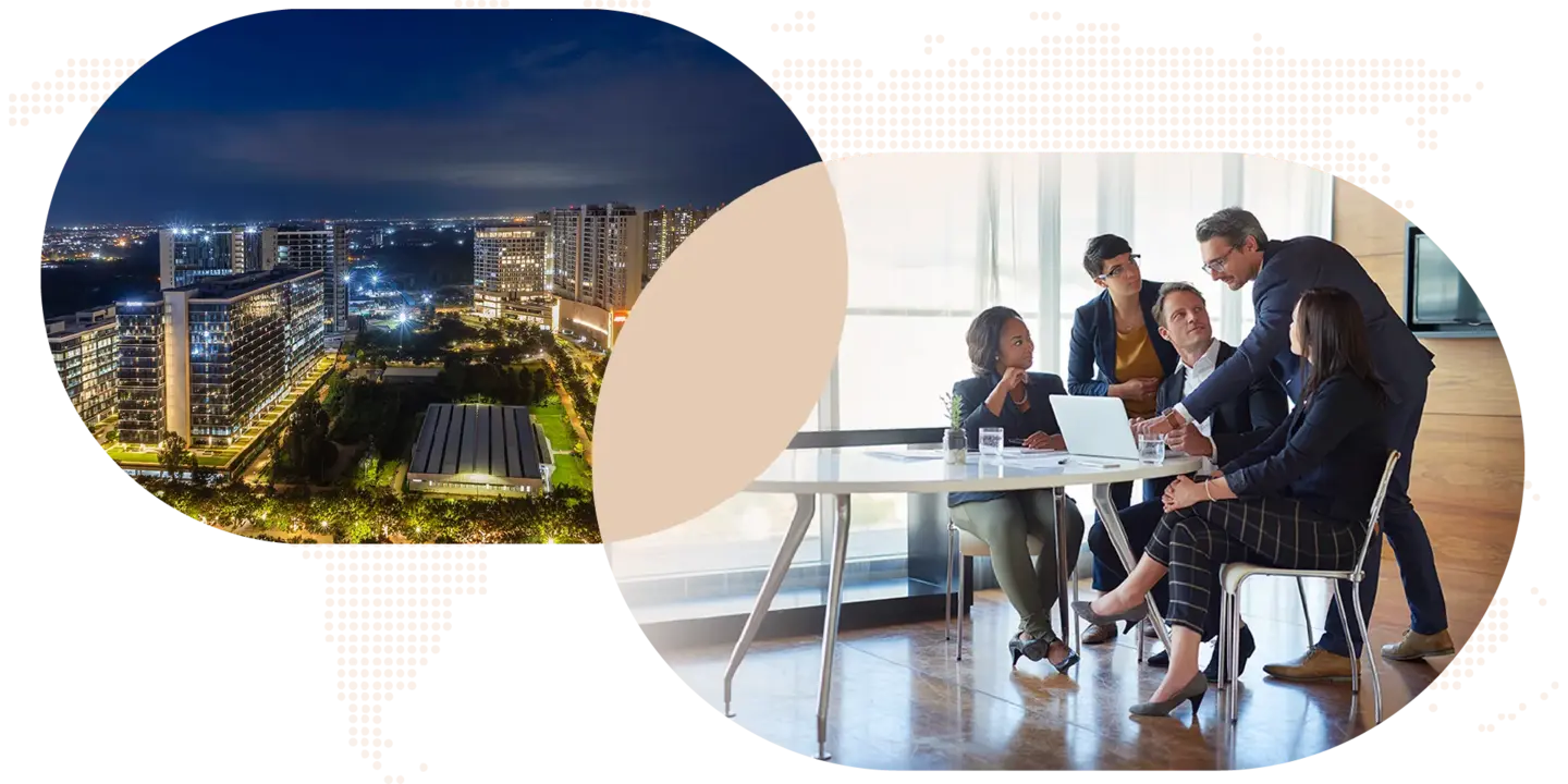 Business team having a meeting around a table with a cityscape at night in the background.