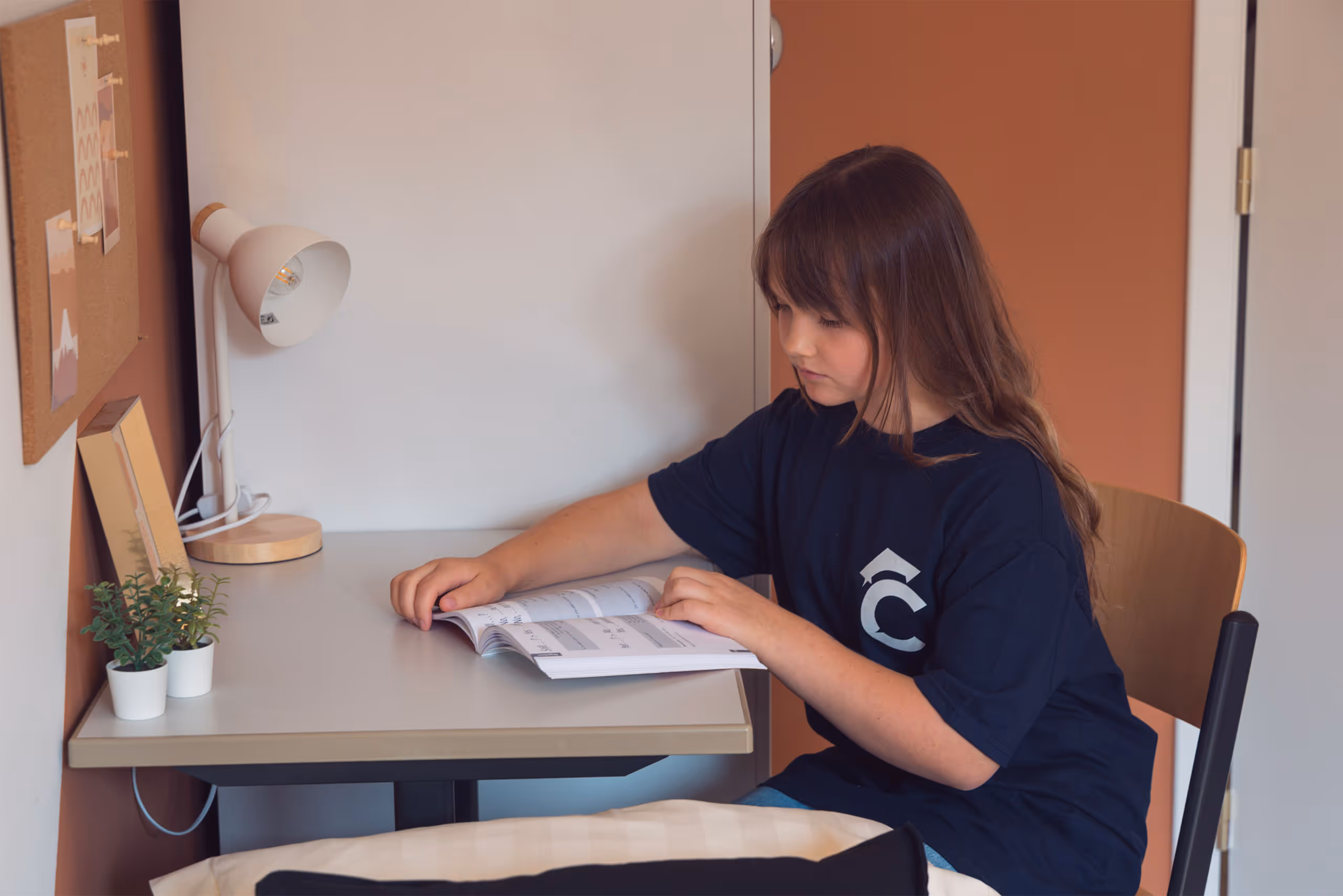Jong meisje studeert aan haar bureau