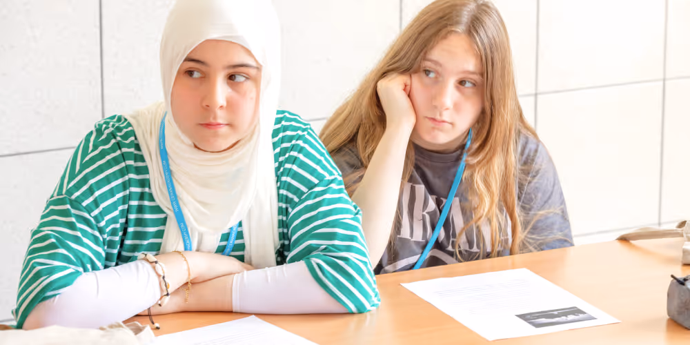 Twee tienermeisjes zitten in de klas tijdens een taalcursus