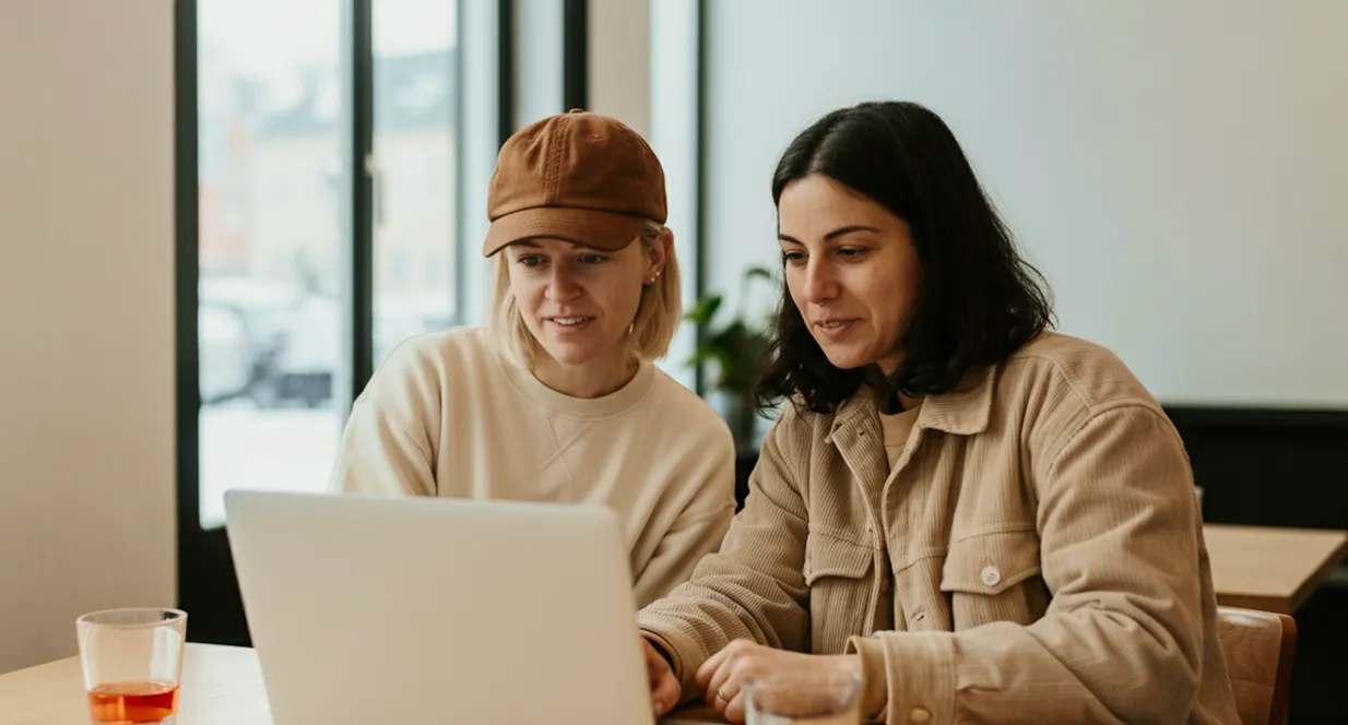 Two women working together on a laptop