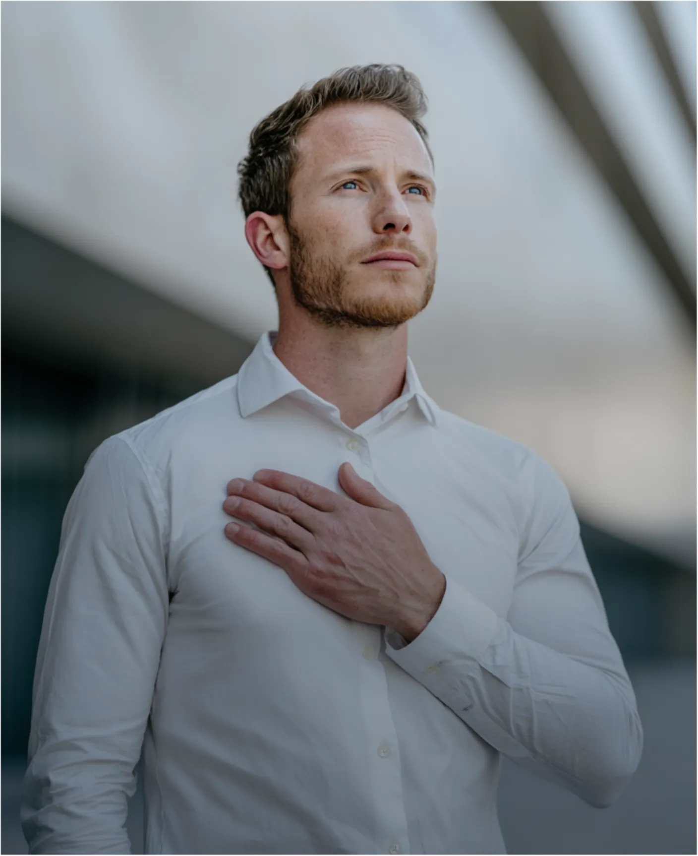 A close-up shot of a hand resting on a person's chest over a light blue striped shirt.