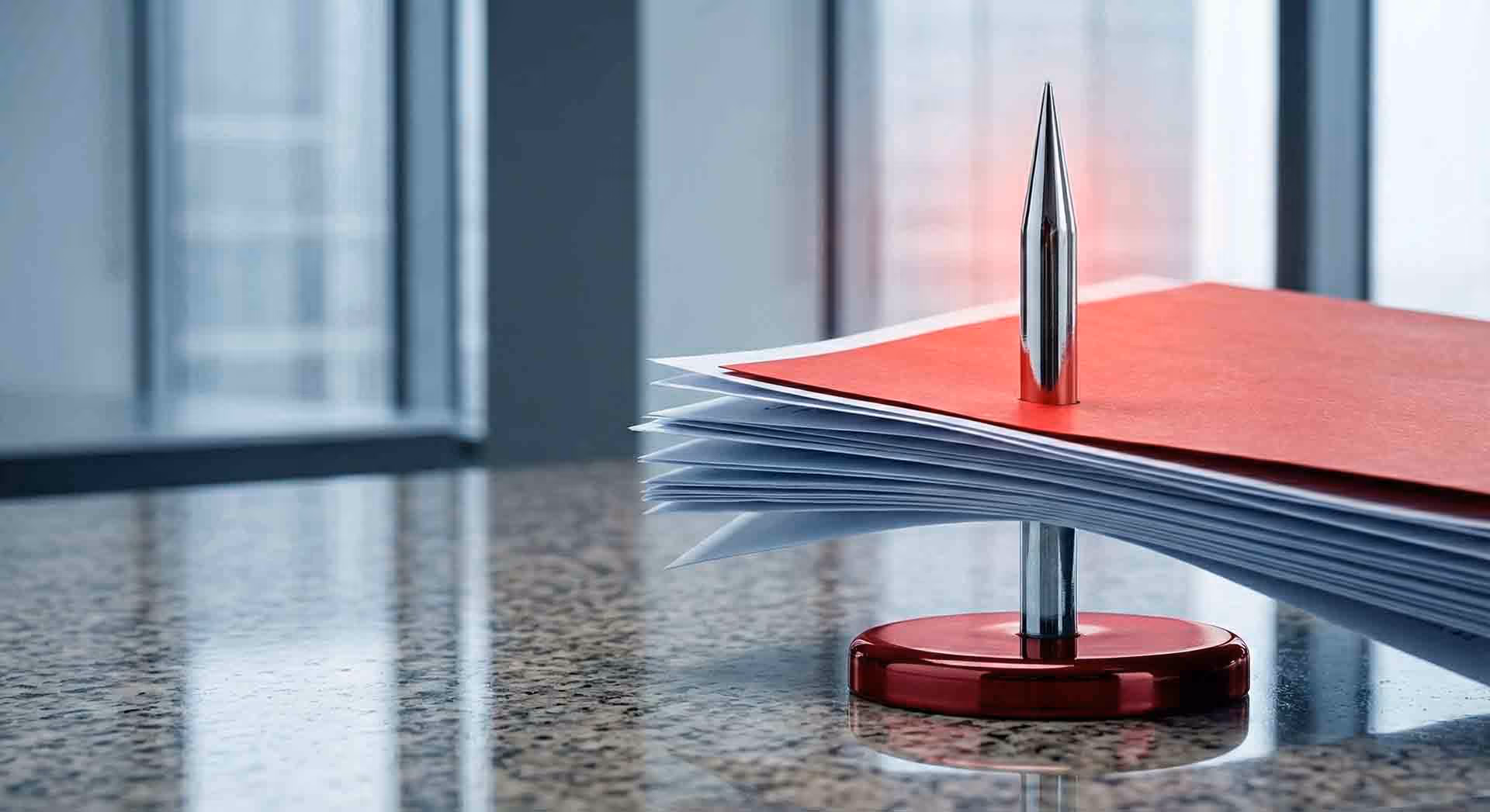 Dokumenty napíchnuté na kancelářském bodci.