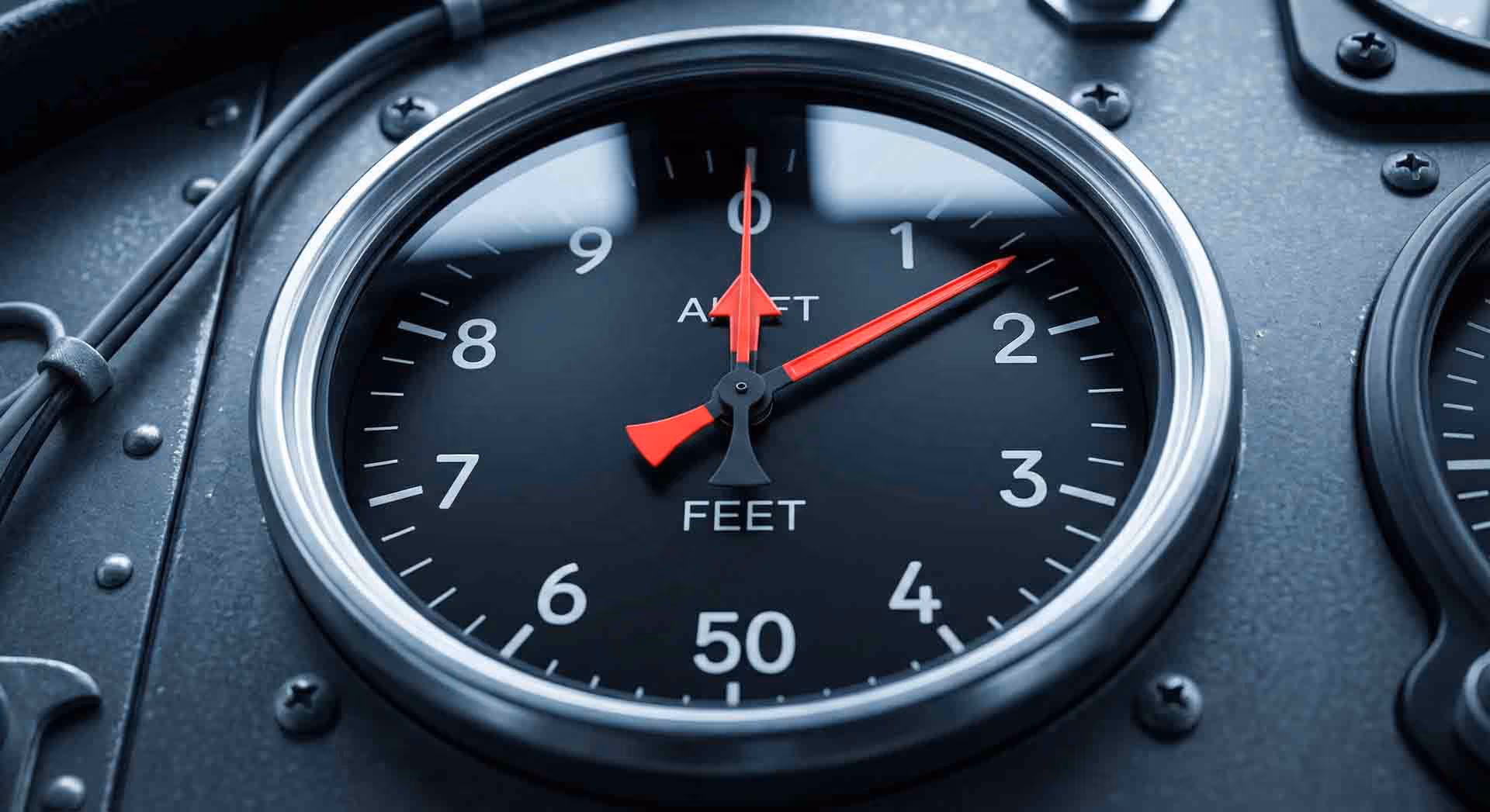 Detail leteckého výškoměru na palubní desce.