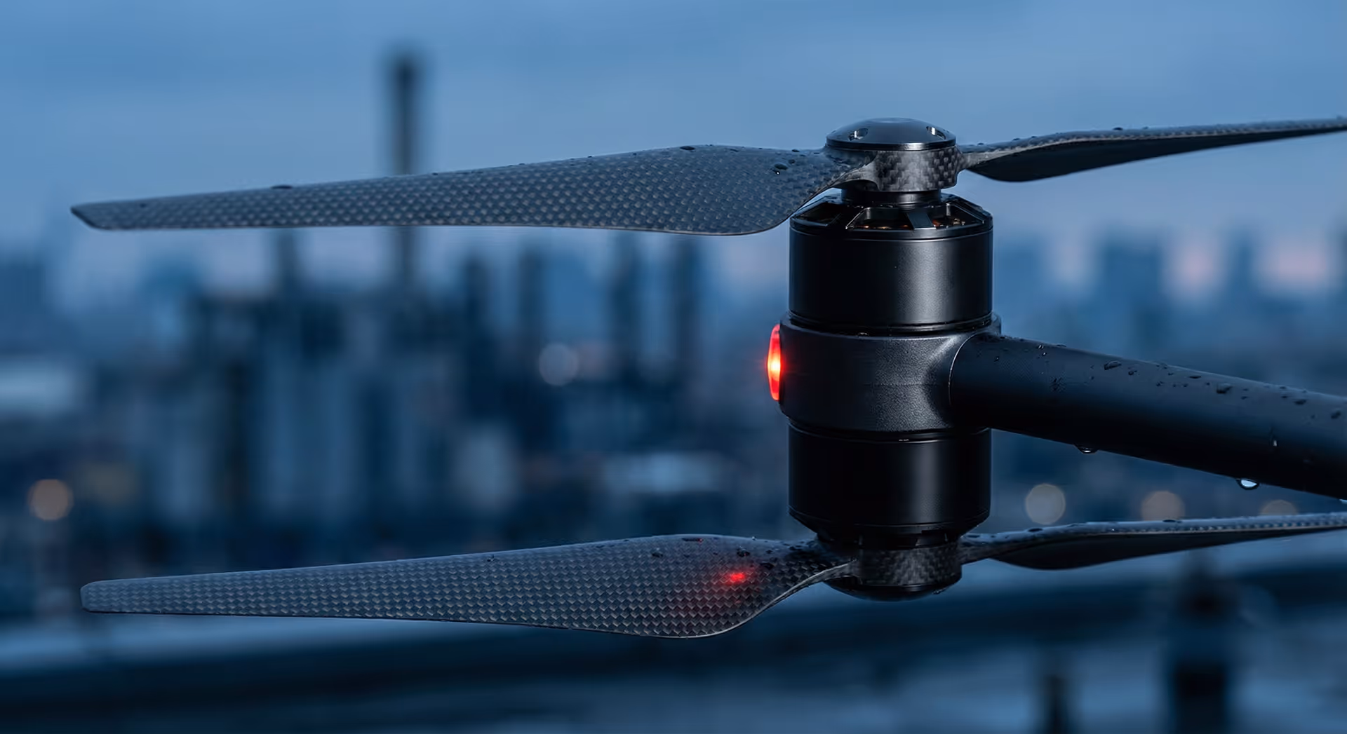 Detail vrtulí dronu s městským pozadím.