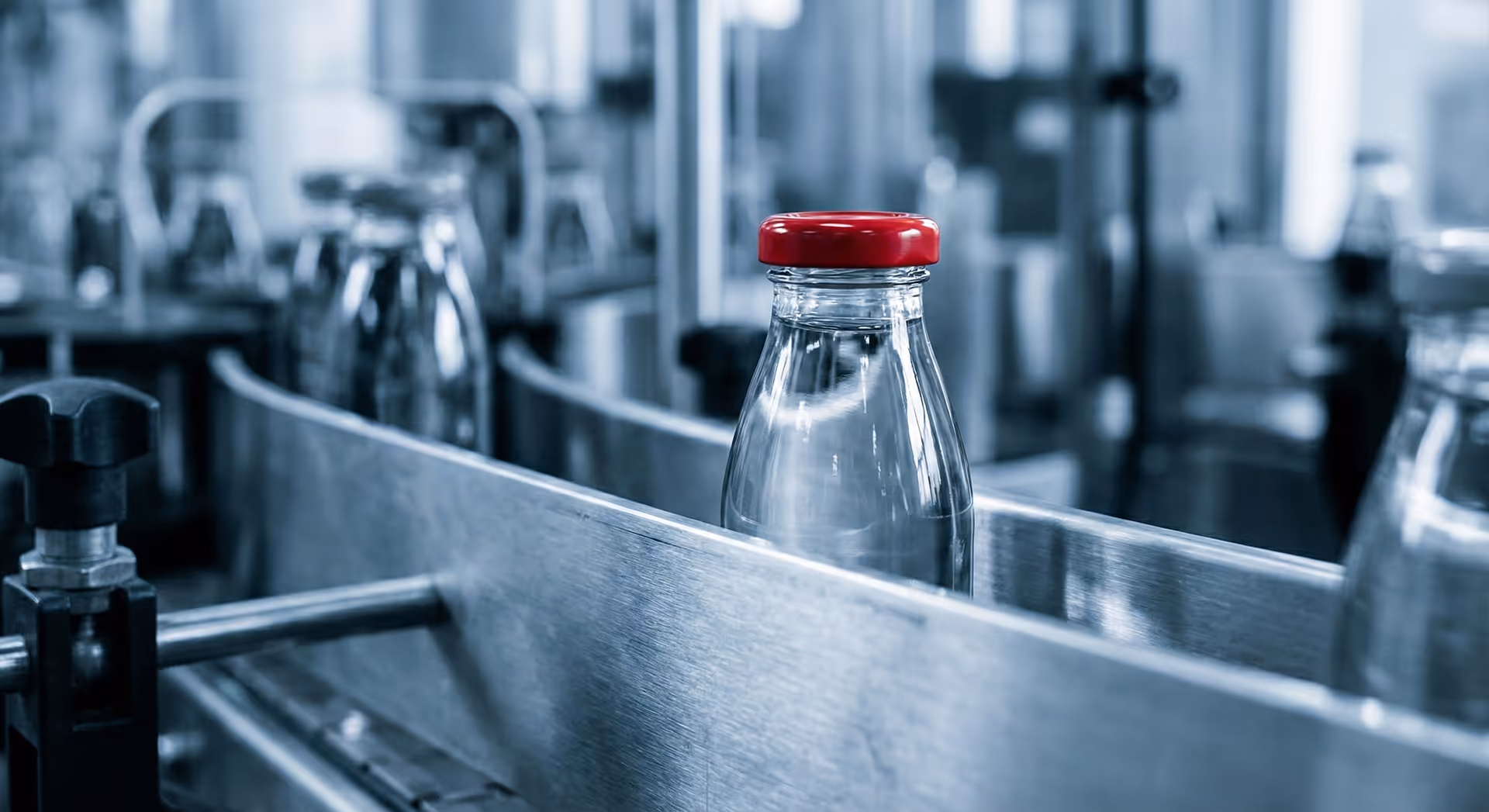 Skleněné lahve jedoucí na výrobním pásu.