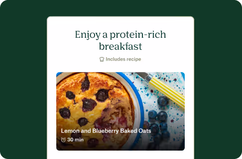 Top view of lemon and blueberry baked oats in a round dish next to scattered blueberries and a yellow-handled spoon.