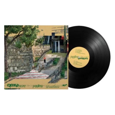 Albumcover von Ashnikko mit einem fantasievollen Cartoon-Gesicht mit blauen Haaren vor einem rosafarbenen Himmel und blauem Vinylschallplatten-Design.