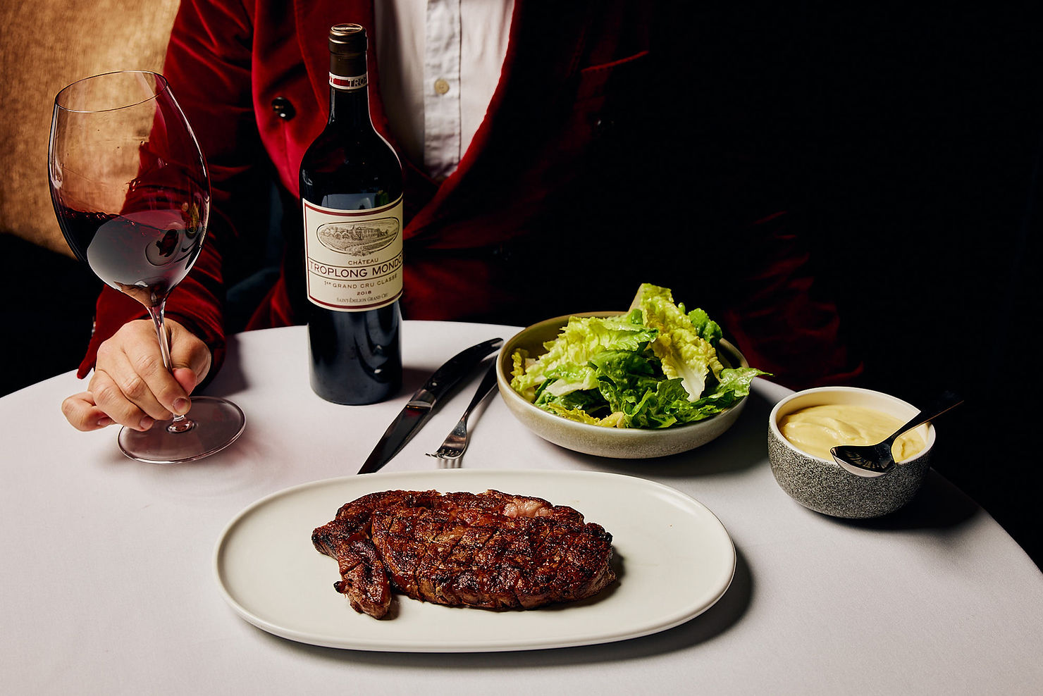 Elegant table setting with a guest enjoying red wine and Wagyu steak at Steer Dining Room, South Yarra, Melbourne, photographed by Tableside Creatives.