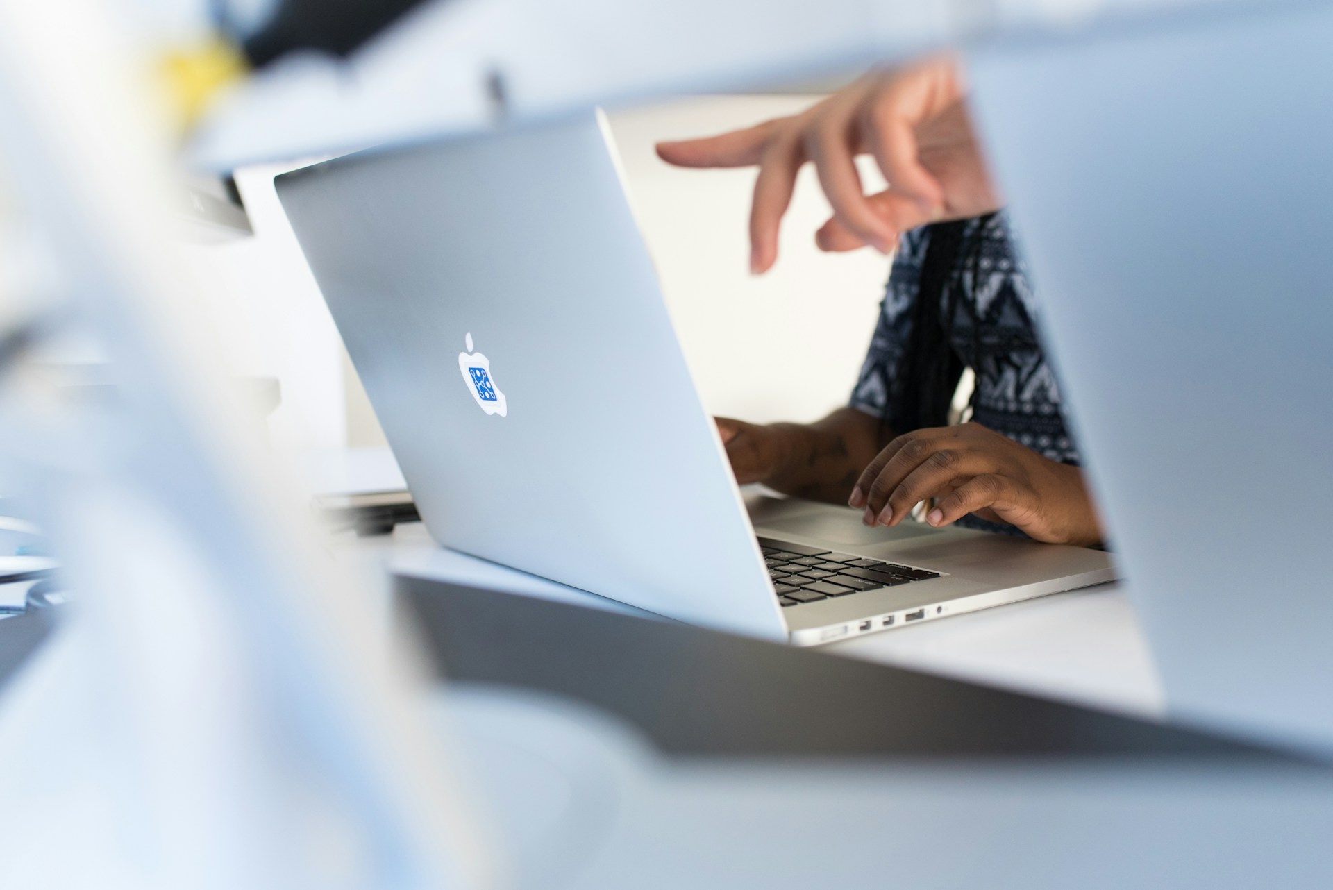 A finger pointing at a laptop screen.