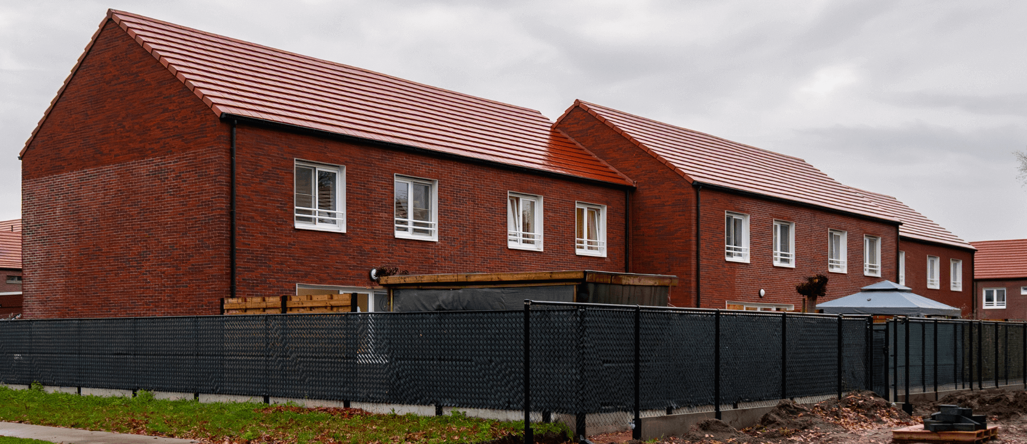 Een foto van onze werf in Retie waar we de dakpannen geplaatst hebben op de hellende daken.