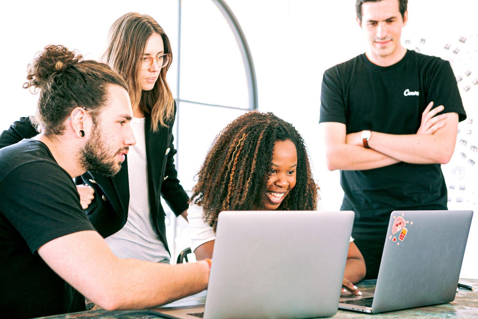 people gathered around a laptop at work