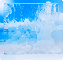 Close-up of clear ice cubes inside a transparent container with a sky background.