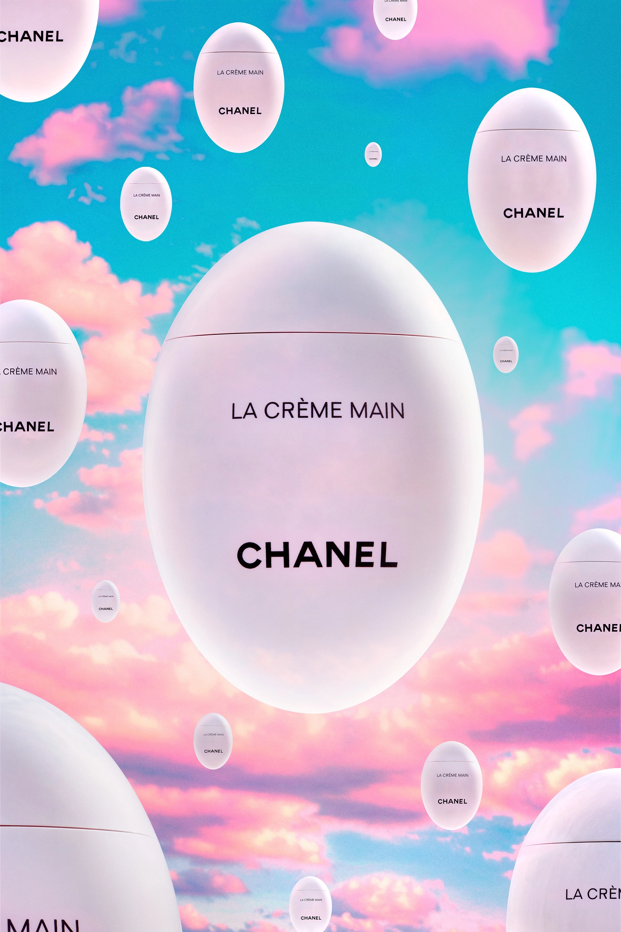 Floating oval Chanel La Crème Main hand cream containers against a blue sky with pink clouds.