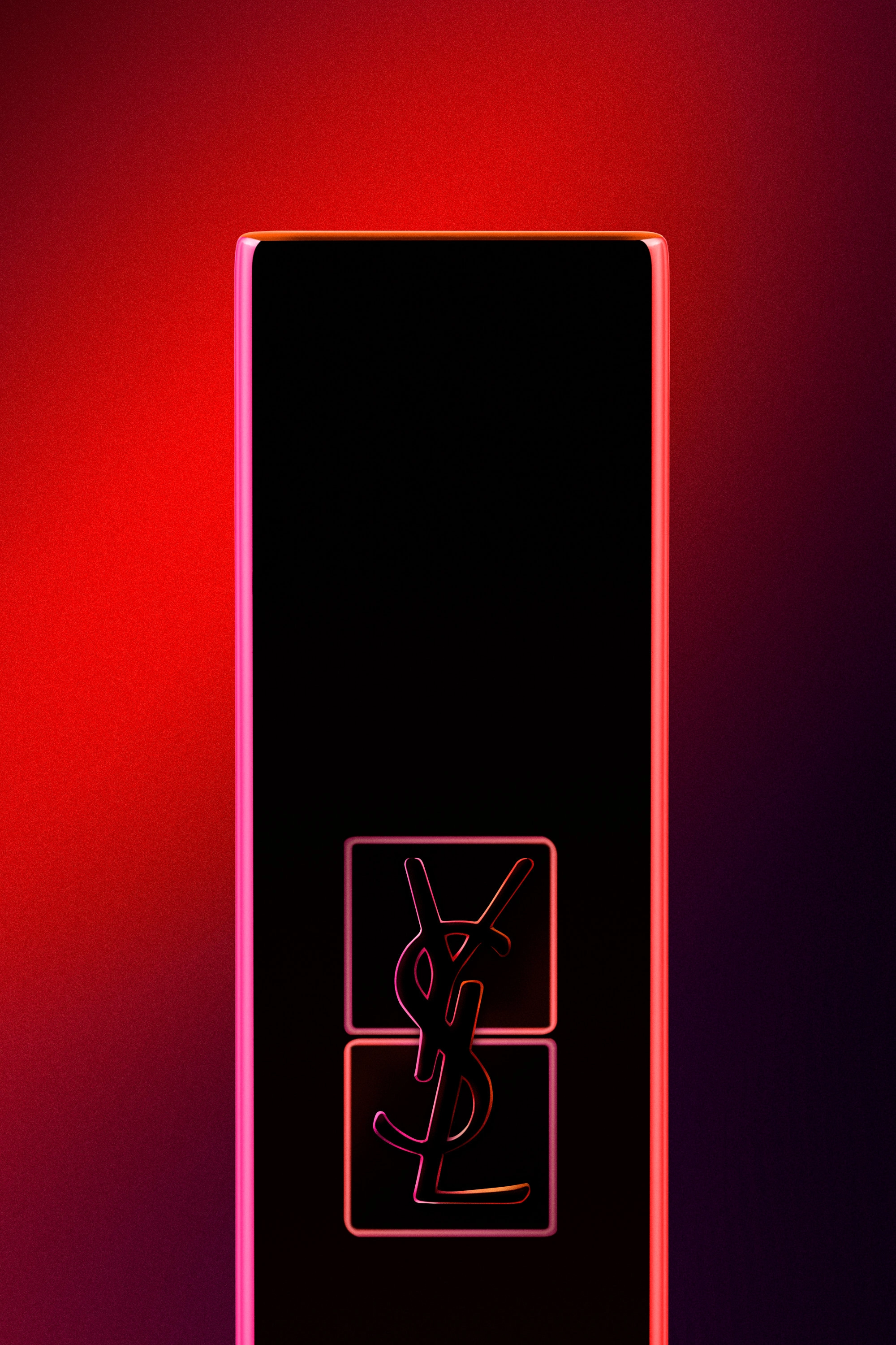 Close-up of a black Yves Saint Laurent lipstick case with glowing red and pink edges against a red background.