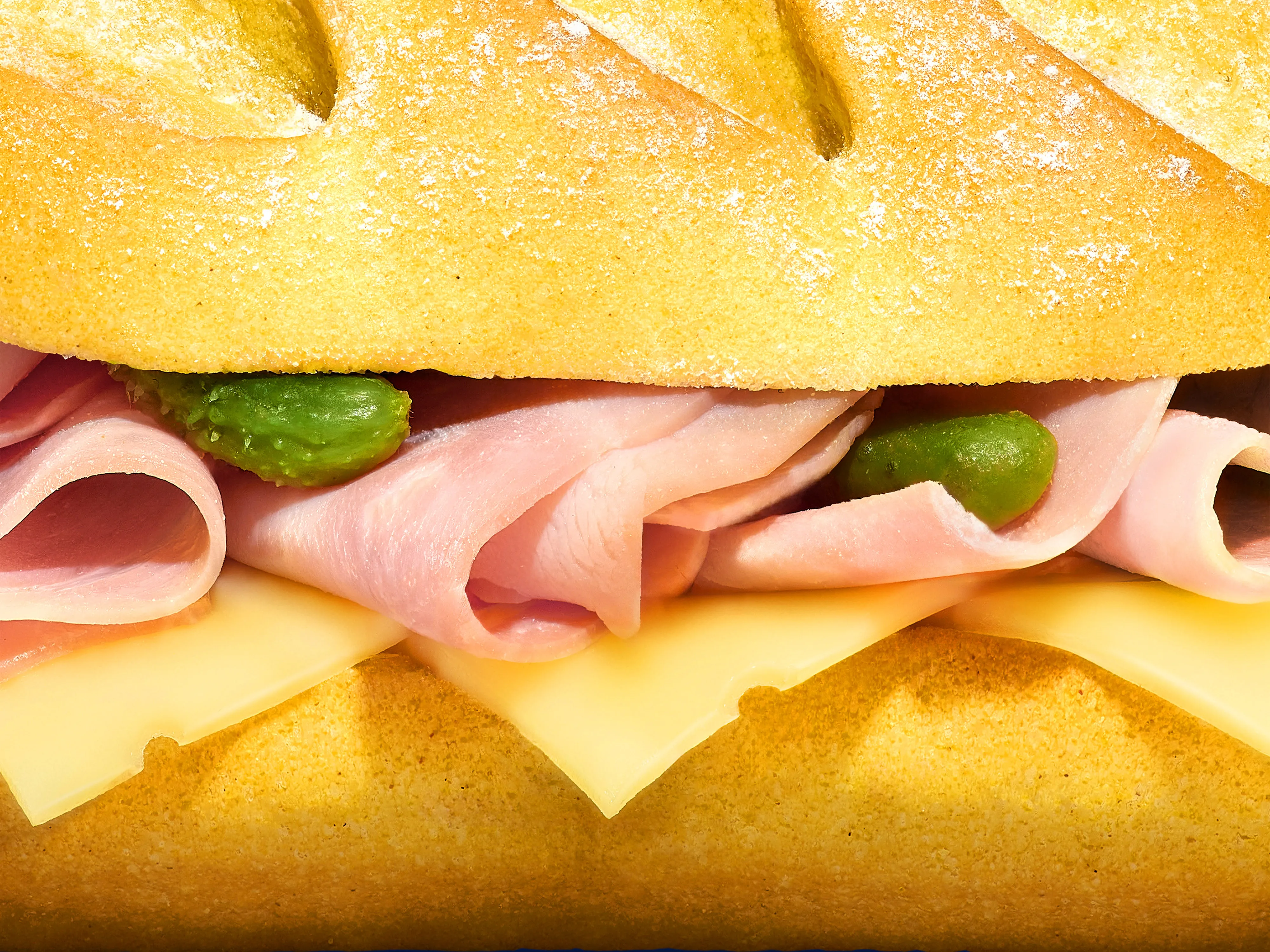 Top portion of a brown glass bottle with a yellow cap covered in condensation droplets.