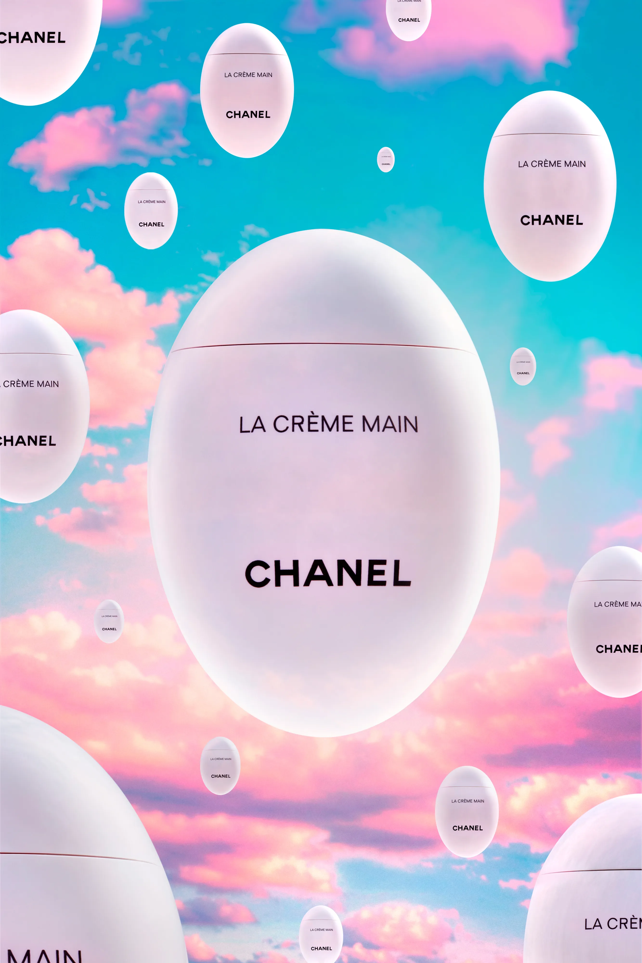 Multiple white egg-shaped Chanel La Crème Main containers floating against a pastel blue and pink sky with clouds.