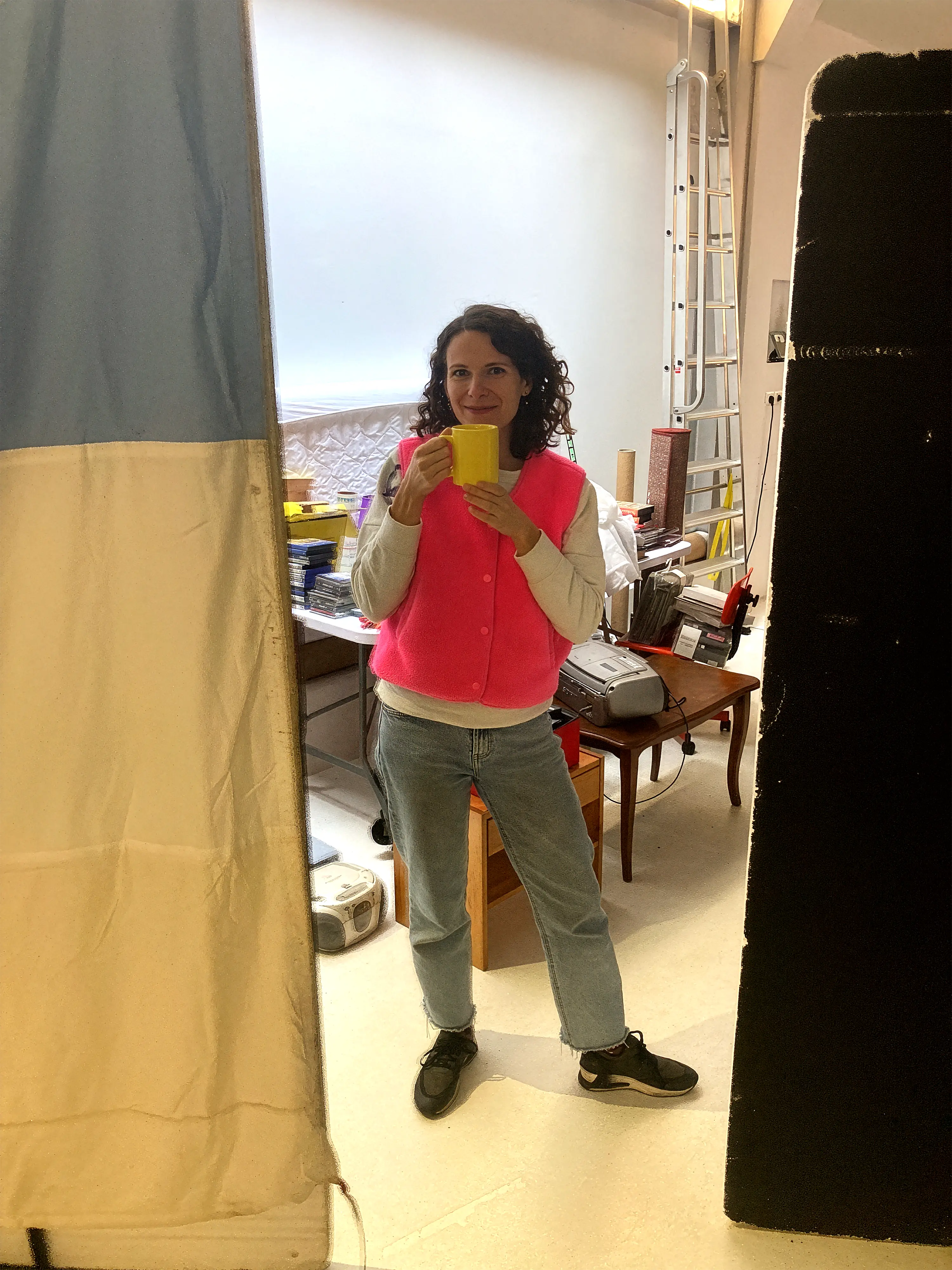 Camera monitor displaying a video frame focused on two people’s legs under red lighting with various camera settings visible.