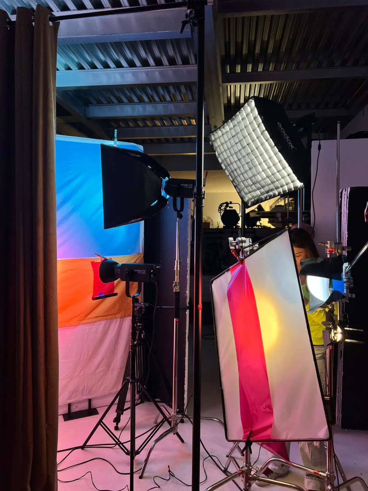 Camera monitor displaying a video frame focused on two people’s legs under red lighting with various camera settings visible.