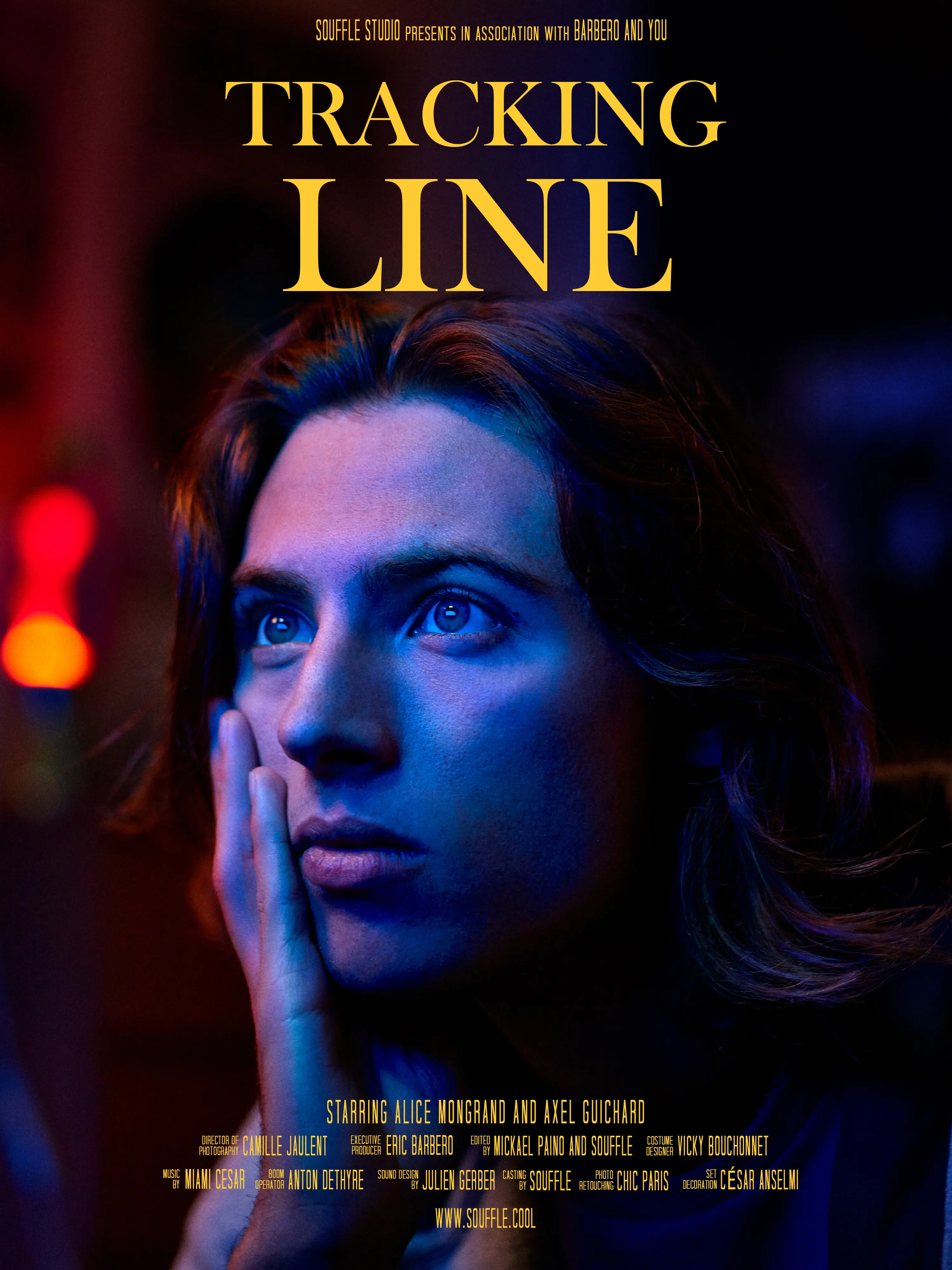 Close-up of a young person’s face illuminated by red and blue light, looking thoughtfully to the side.