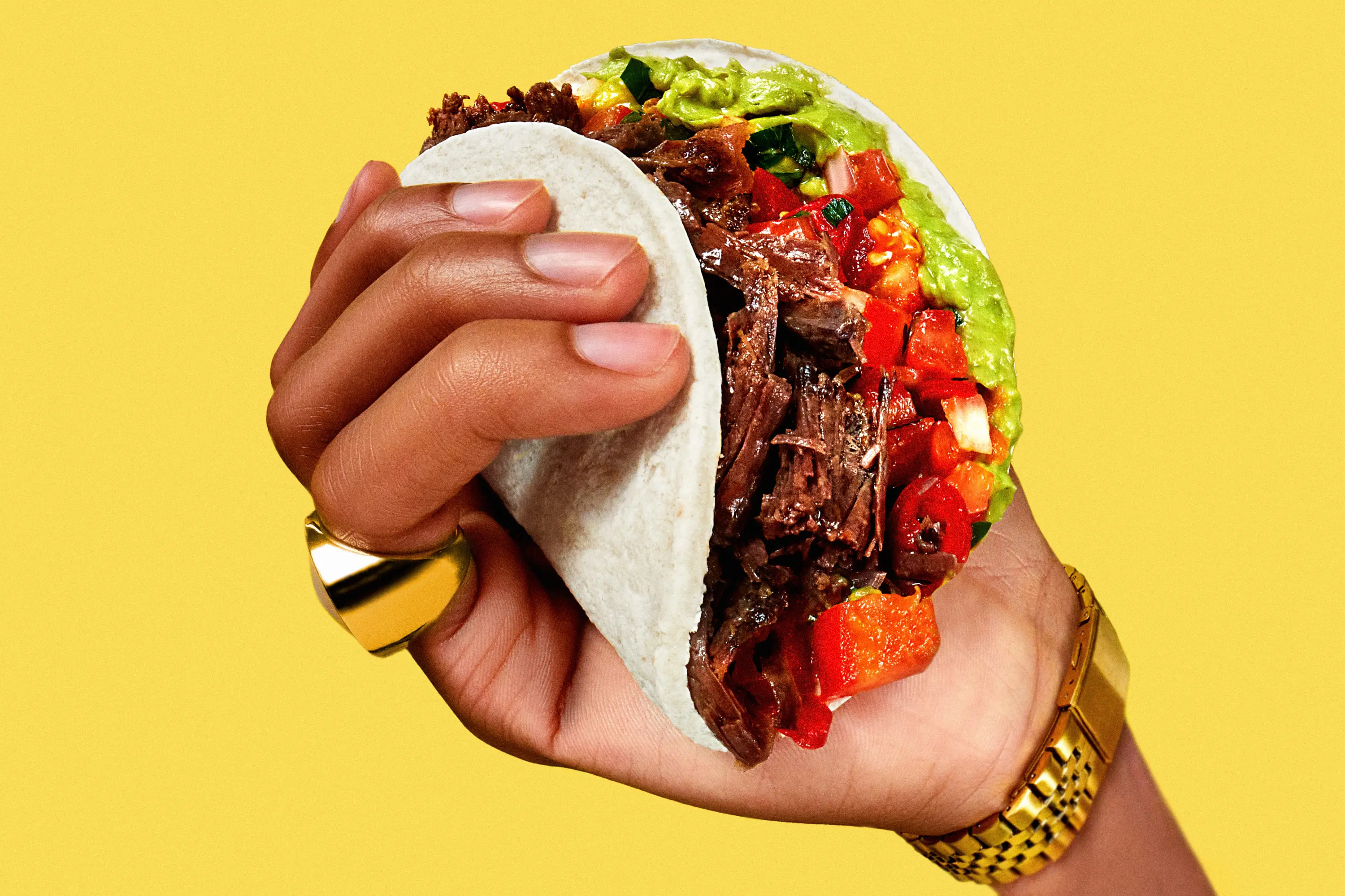 Two bottles of Meteor IPA beer with condensation on a glass table surrounded by snacks, a bottle opener, and a record player in a cozy room.