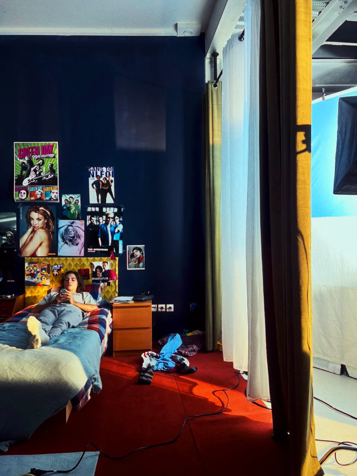 Camera monitor displaying a video frame focused on two people’s legs under red lighting with various camera settings visible.